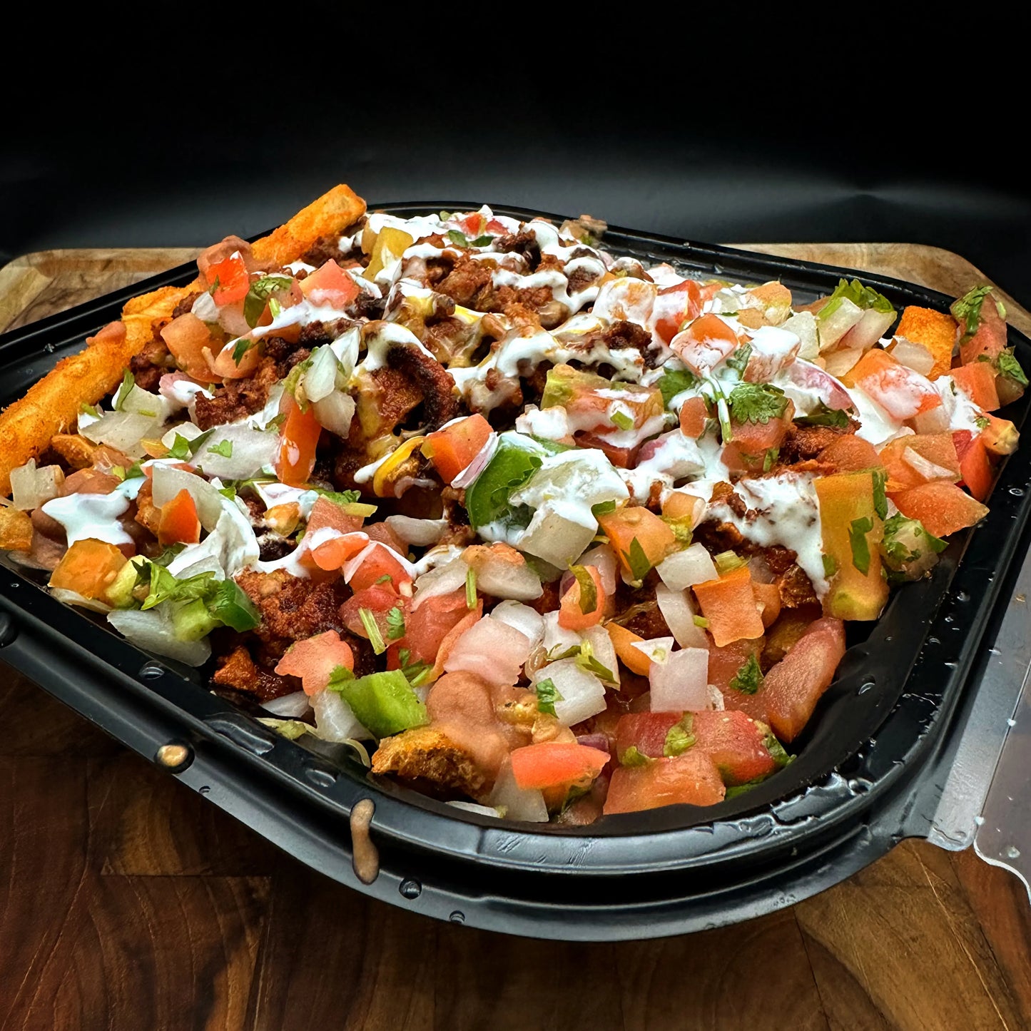 Carnivore Fries with French fries, meat, pico de gallo, beans, and queso blanco.