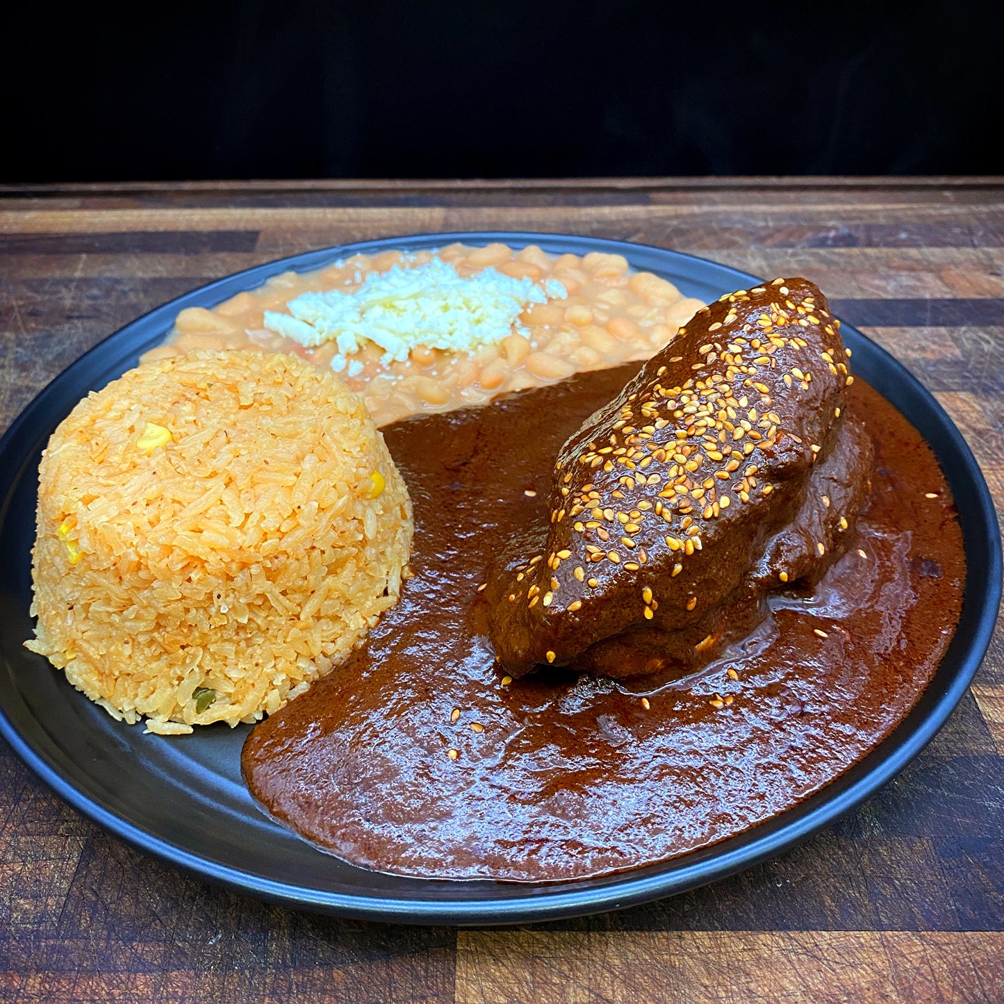 Mole Poblano Plate with chicken, tortillas, rice, and beans.