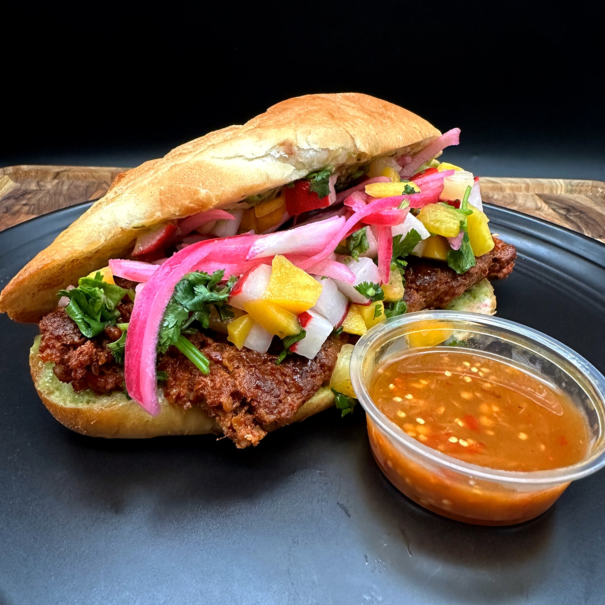 Al pastor choripan with Mexican chorizo, pineapple, mango and jalapeno salsa on bolillo roll with seasoned fries