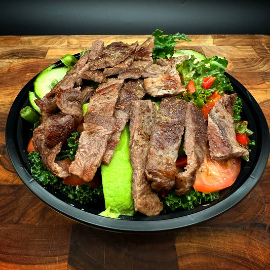 Steak Keto Bowl with Flat Iron Steak, asparagus, bell pepper, cucumber, tomato, kale, and avocado.