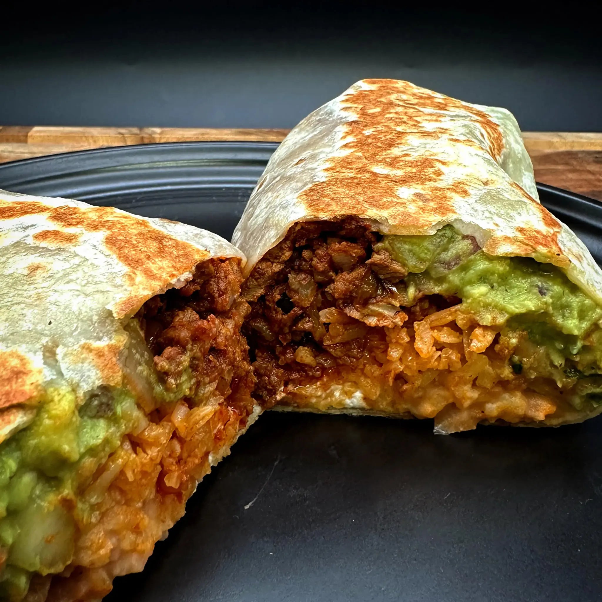 Burrito with meat, guacamole, Mexican cream, rice, beans, and cheese.