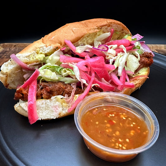 Salvadoran style choripan with in-house sausage, shredded cabbage and pickled onions on bolillo roll with seasoned fries