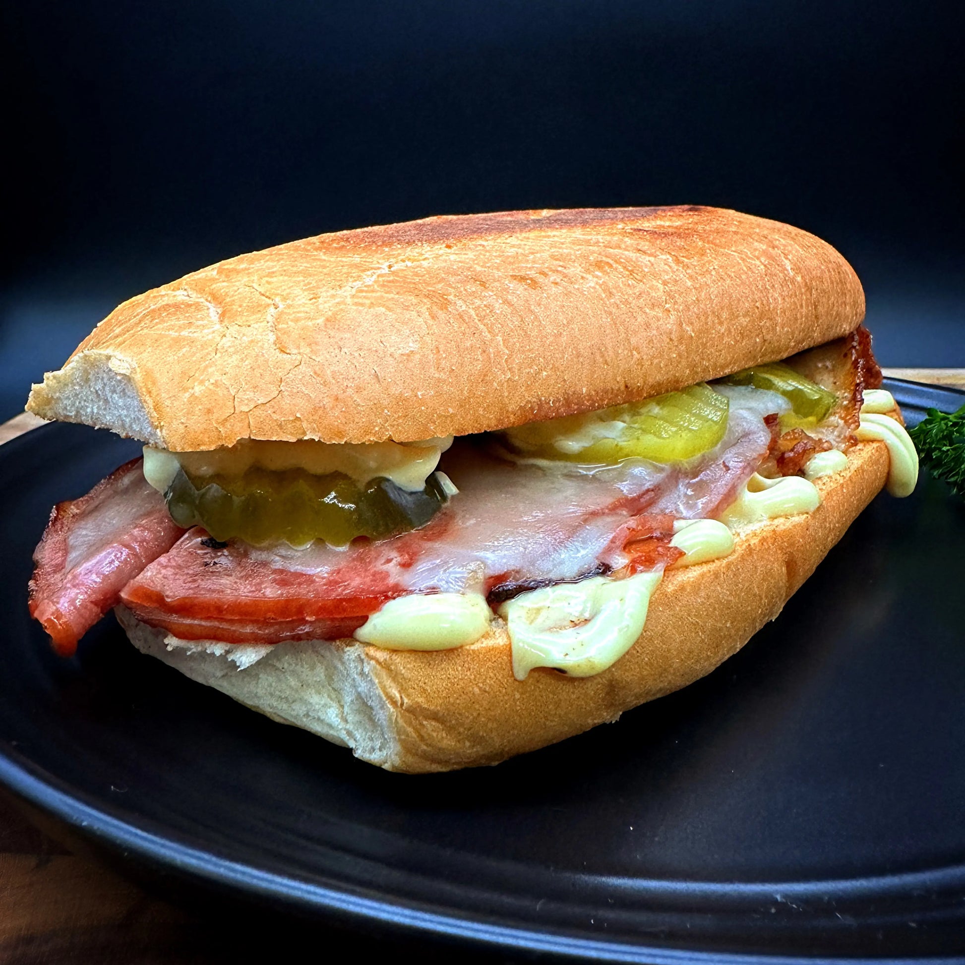 Cuban Sandwich with pork leg, ham, pickles, mustard, mayo, and provolone cheese.