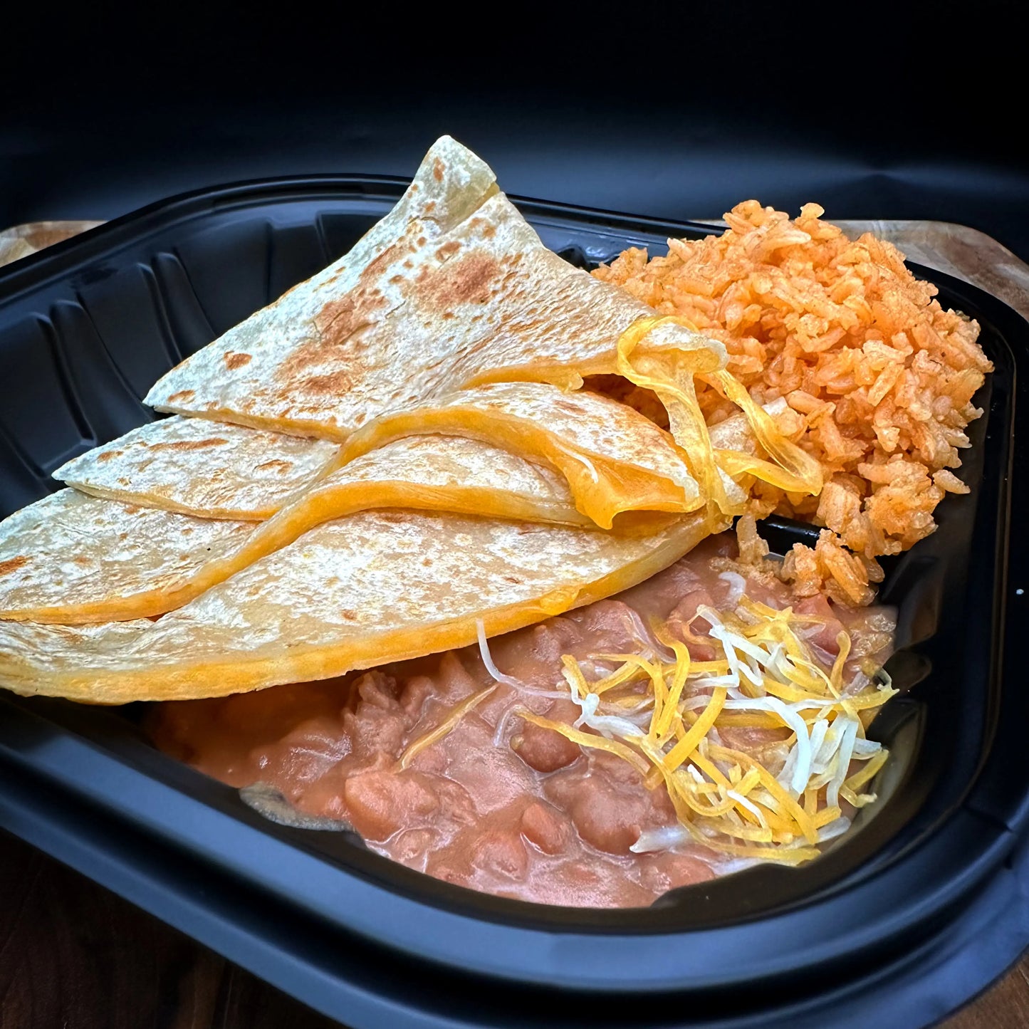 Regular Cheese Quesadilla served with rice and beans.