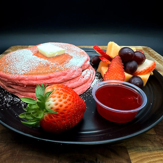 Strawberry and Cream Cheese Pancakes with strawberry syrup, cream cheese, butter, and seasonal fruit.
